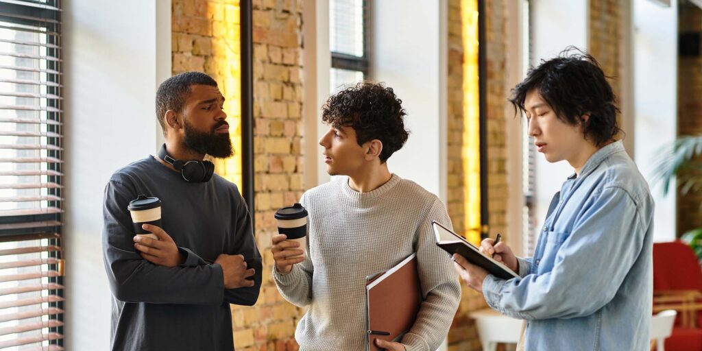 three-colleagues-engage-in-a-lively-discussion-ove-VW2E763.jpg